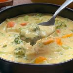 bowl of broccoli cheese soup garnished with shredded cheese