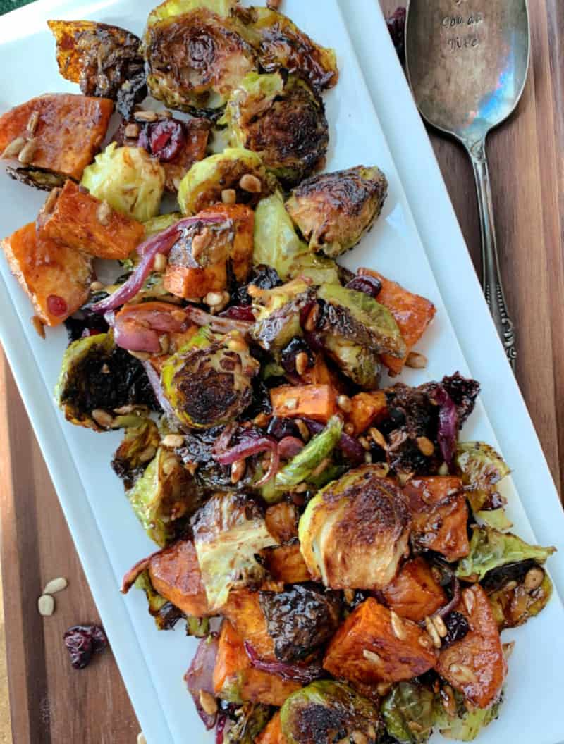 white plate with roasted brussels sprouts and sweet potatoes