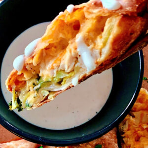buffalo chicken egg rolls cut in half with side of ranch dressing