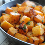black bowl with air fryer butternut squash garnished with parsley