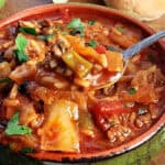 green bowl with stuffed cabbage soup and spoon scooping some out