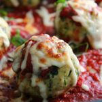 closeup of chicken parmesan meatballs topped with melted mozzarella