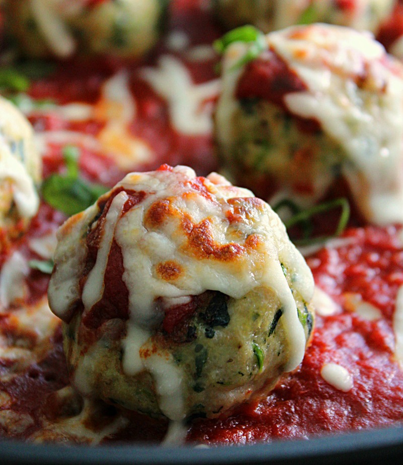 closeup of chicken parmesan meatballs topped with melted mozzarella
