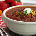 white bowl with easy ground beef chili topped with shredded cheese and sour cream