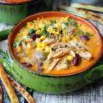 overhead view green bowl with slow cooker chicken enchilada soup garnished with cilantro