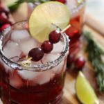 2 cranberry christmas margaritas garnished with fresh cranberries, lime slice and fresh cranberries