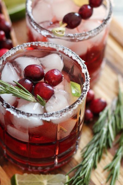 cranberry christmas margaritas in salt rimmed glasses garnished with fresh cranberries