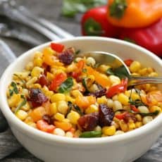 white bowl filled with corn, diced bell pepper and pieces of crispy bacon.