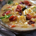 closeup of bowl of Creamy Corn Chowder garnished with fresh basil leaves