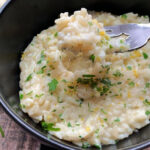 overhead view black bowl with creamy parmesan rice and forkful