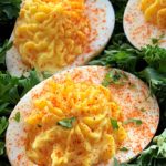 close up of deviled eggs garnished with paprika and parsley