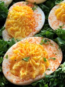 close up of deviled eggs garnished with paprika and parsley