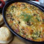 black casserole dish with scrambled egg casserole garnished with fresh dill