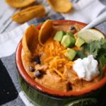 overhead view - bowl of soup topped with extra cheese and sour cream