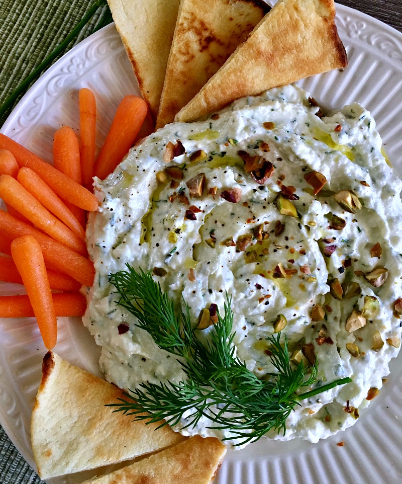 overhead view - white plate with garlic feta dip garnished with chopped nuts