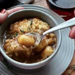 bowl of french onio soup gnocchi with spoonful lifted