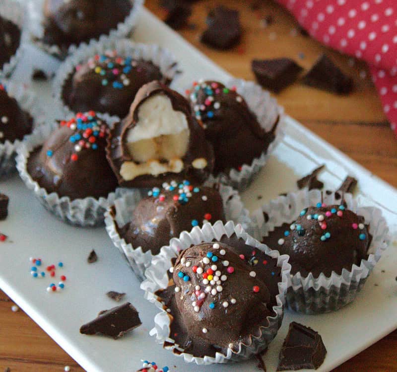 white platter with frozen chocolate banana bites topped with colored sprinkles