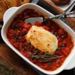 white baking dish with baked goat cheese and roasted tomatoes