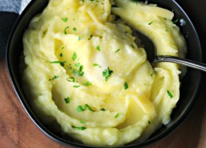 black bowl with smoked gouda mashed potatoes and pat of melting butter