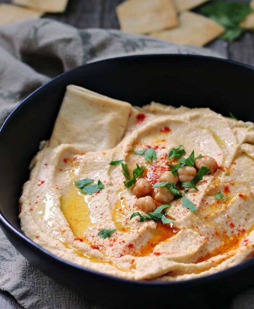 what to serve with naan - bowl of hummus shown garnished with chickpeas