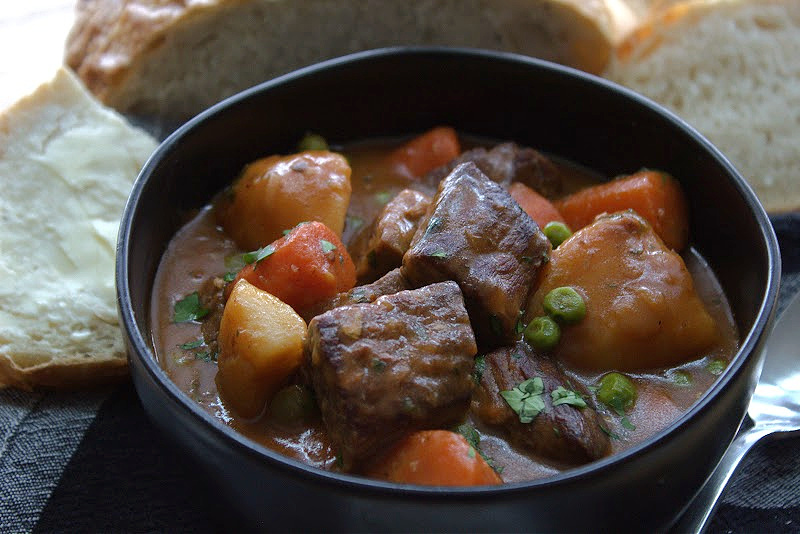 black bowl with irish guinness beef stew and sliced bread