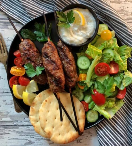 kofta kabobs served with naan bread, salad and tzatziki