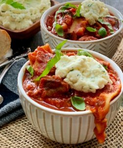 bowls of slow cooker lasagna soup topped with a dollop of ricotta cheese