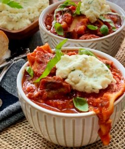 bowls of lasagna soup topped with a dollop of ricotta cheese
