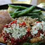 black plate with baked lemon grouper, green beans and quinoa