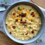 overhead view gray bowl with loaded mac and cheese garnished with bacon and green onions