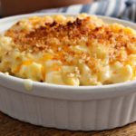 white casserole dish with creamy mac and cheese and golden breadcrumbs on top