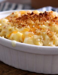 White baking dish with creamy mac and cheese topped with golden breadcrumbs