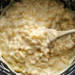 saucepan with spoon showing mac and cheese