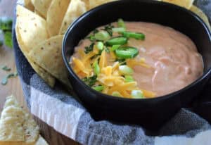 black bowl with mexicali dip garnished with sliced jalapenos