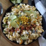 black bowl with mexican street corn pasta salad garnished with crispy bacon