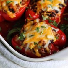 Mexican Stuffed Peppers ~ seasoned ground beef, rice and black beans topped with cheese and baked in colorful bell peppers and a bold enchilada sauce.