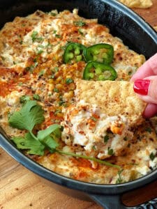 closeup of Mexican Street Corn Dip scooped on a tortilla chip
