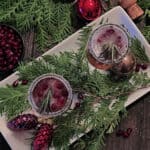 overhead view of two mistletoe mimosas garnished with a sprig of rosemary and pomegranate seeds