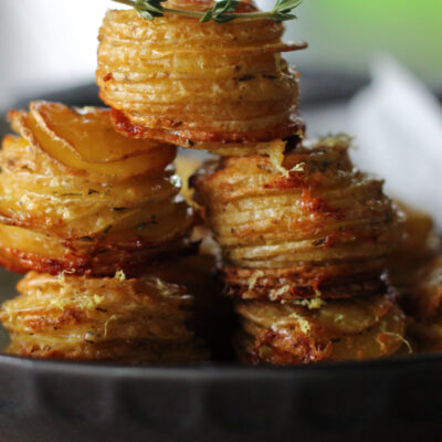Muffin Tin Potato Stacks on black plate garnished with fresh thyme