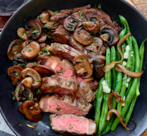 overhead view steak, green beans and caramelized onions and mushrooms