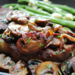 closeup of steak with caramelized onions and mushrooms