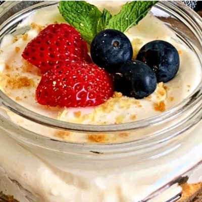 Pinterest pin showing No Bake Cheesecake in a mason jar topped with berries
