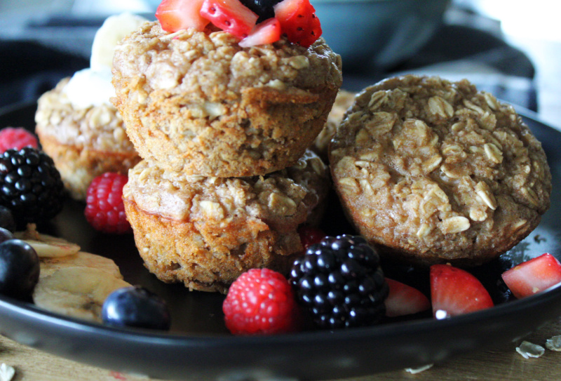 black plate with baked oatmeal cups and fresh berries