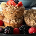 black plate with several baked oatmeal cups and assorted fruit