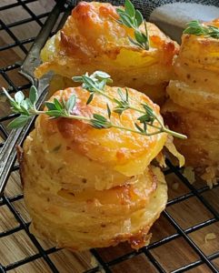 potato stacks garnished with thyme sprig on baking rack