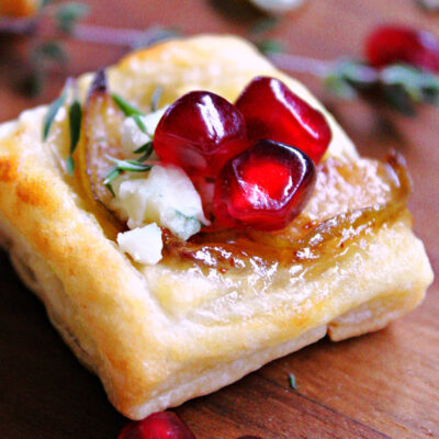 closeup of christmas puff pastry appetizer garnished with pomegranate seeds
