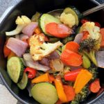 overhead view - black bowl filled with bright colored roasted vegetables