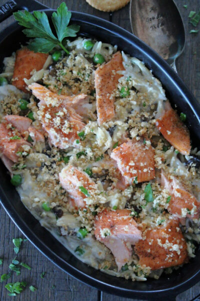 black casserole dish with salmon casserole topped with crispy crushed Ritz crackers