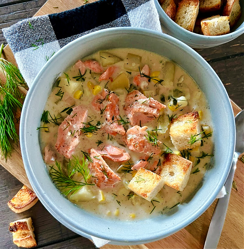 overhead view gray bowl with salmon chowder garnished with sourdough croutons
