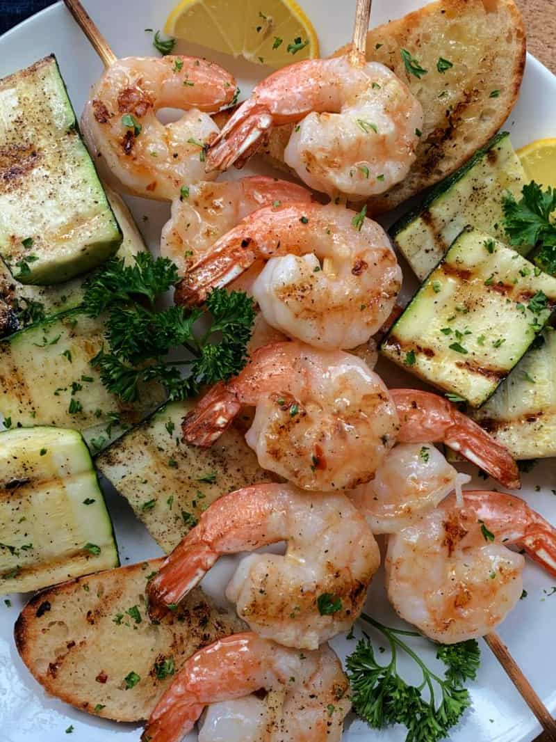 grilled lemon garlic shrimp scampi skewers on white plate